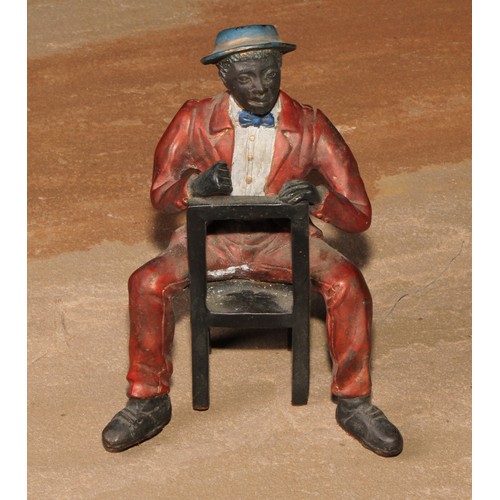 184 - A cold painted bronze, of a Mississippi dandy, seated backwards on a chair, 13.5cm high; another (2)