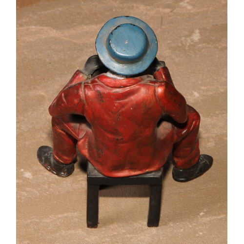 184 - A cold painted bronze, of a Mississippi dandy, seated backwards on a chair, 13.5cm high; another (2)