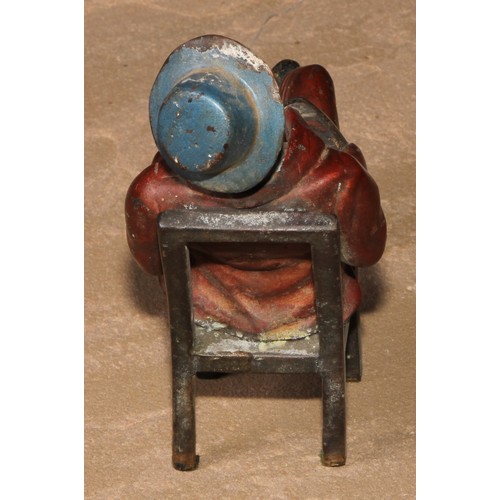 184 - A cold painted bronze, of a Mississippi dandy, seated backwards on a chair, 13.5cm high; another (2)