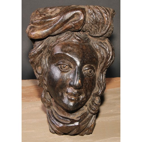 84 - A 19th century oak wall boss or mask, carved in the Baroque manner as the head of a lady, 28.5cm hig... 