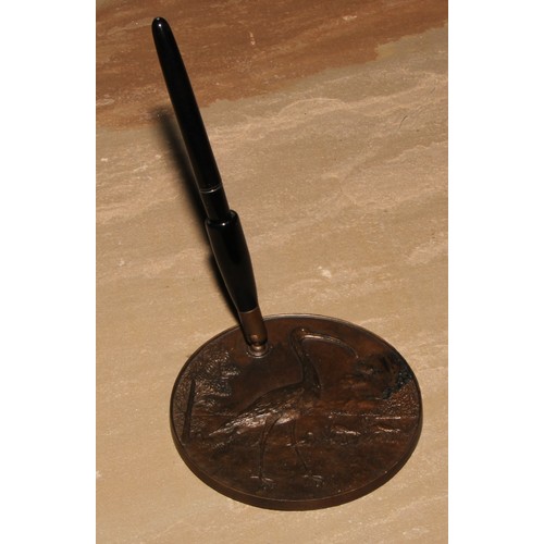 129 - A bronze desk top pen stand, cast in relief in the Aesthetic Movement Japanese taste with a stork, 1... 