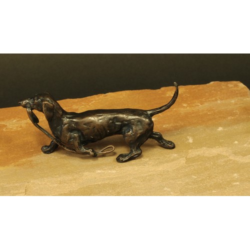 528 - Continental School (20th century), a brown patinated bronze, of a dachshund carrying a lead, monogra... 