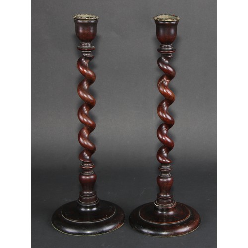 673 - Treen - a pair of mahogany spirally turned table candlesticks, circular bases, 39cm high, early 20th... 