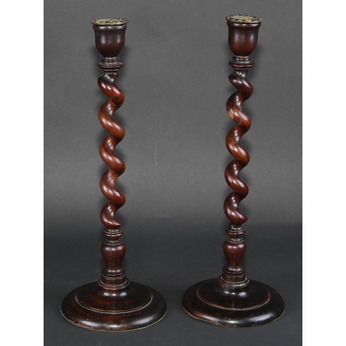 673 - Treen - a pair of mahogany spirally turned table candlesticks, circular bases, 39cm high, early 20th... 