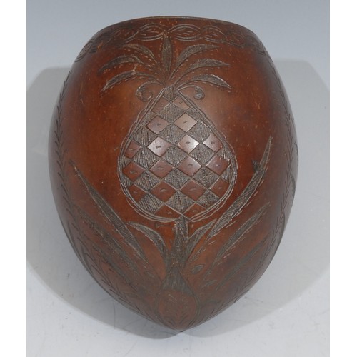 37 - A 19th century coconut cup, carved with a pineapple, coconut trees and leaves, 12cm high