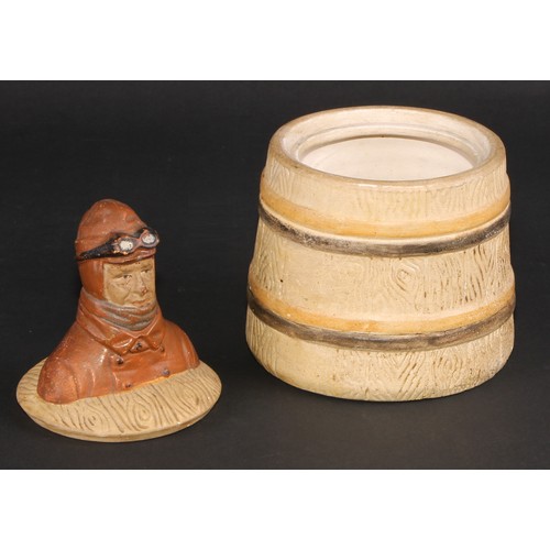 467 - An early 20th century stoneware novelty tobacco jar, the cover with a vintage motorist, bust length,... 