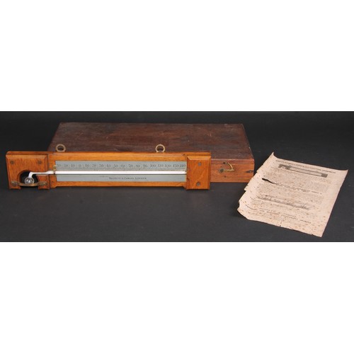 293 - A Negretti & Zambra minimum self-registering thermometer, silvered register, oak mount, 35.5cm long