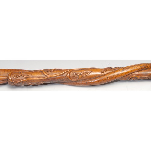 747 - An Indian walking stick, carved with a figure and a cobra, the entwined shaft with a meandering flow... 