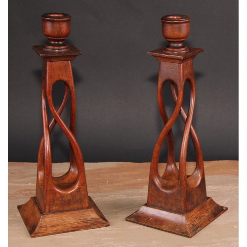 675 - Treen - a pair of unusual mahogany square open-twist table candlesticks, spreading bases, 34cm high,... 