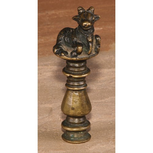 487 - An Indian brass desk seal, crested by a recumbent cow, monogram to matrix, 9cm long, 19th century