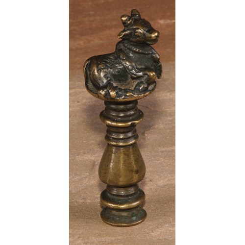 487 - An Indian brass desk seal, crested by a recumbent cow, monogram to matrix, 9cm long, 19th century