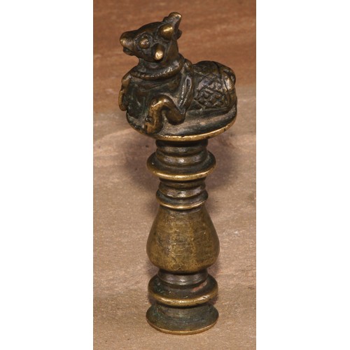 487 - An Indian brass desk seal, crested by a recumbent cow, monogram to matrix, 9cm long, 19th century