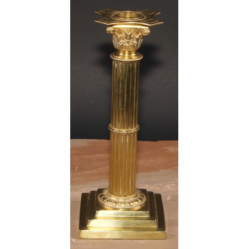 693 - A pair of brass Corinthian column candlesticks, detachable nozzles, fluted columns, stepped square b... 