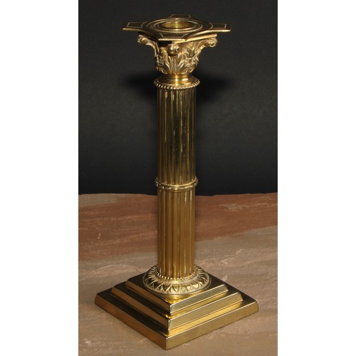 693 - A pair of brass Corinthian column candlesticks, detachable nozzles, fluted columns, stepped square b... 