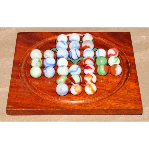 71 - A 19th century mahogany double-sided solitaire board, 15.5cm wider, marbles en suite