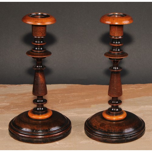 674 - Treen - a pair of turned fruitwood candlesticks, 24cm high