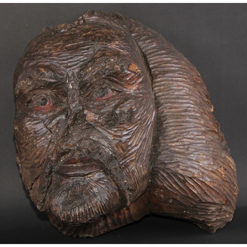 253 - A large folk art burr wood mask, carved as a grotesque face, the features picked out in red pigment,... 