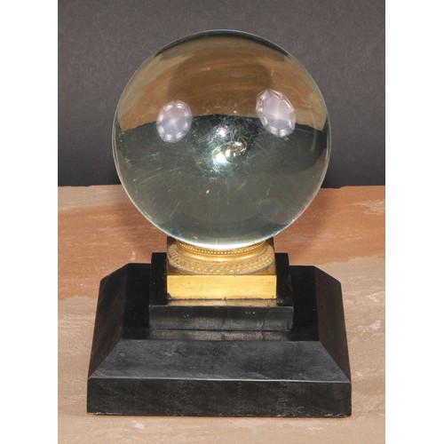 627 - Mysticism and the Occult - a crystal ball, gilt metal mounted ebonised stand, 18cm high overall