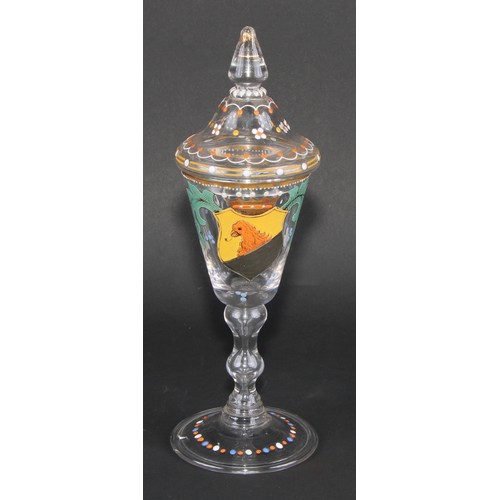 324 - A pair of Continental glass goblets and covers, each decorated in polychrome enamels with armorials ... 