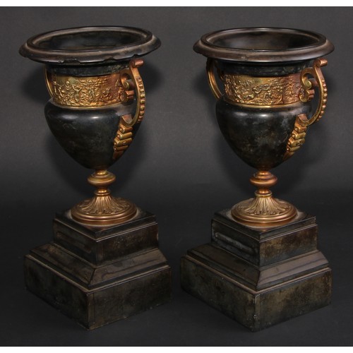 311 - A pair of 19th century gilt metal mounted black marble campana mantel urns, each with turned rim abo... 