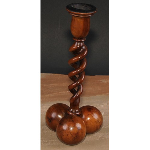 341 - A pair of Middle Eastern olivewood open-twist candlesticks, each triform base composed of three sphe... 