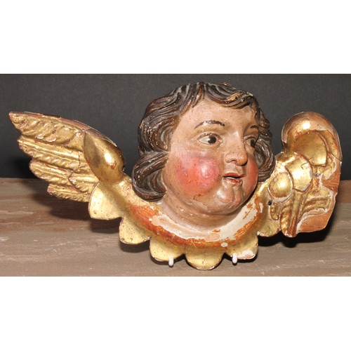 496 - An Italian Baroque polychrome painted and gilt carving, the head of a putto, 28cm wide, 18th/19th ce... 