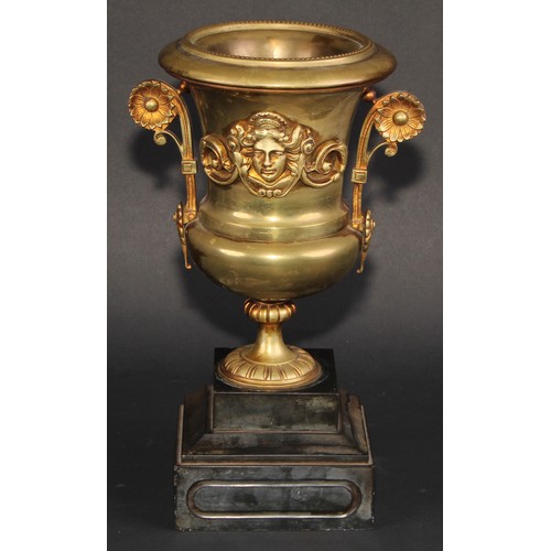 294 - A Neo-Classical Revival brass campana mantel urn, applied with a cast mask, scroll handles terminati... 