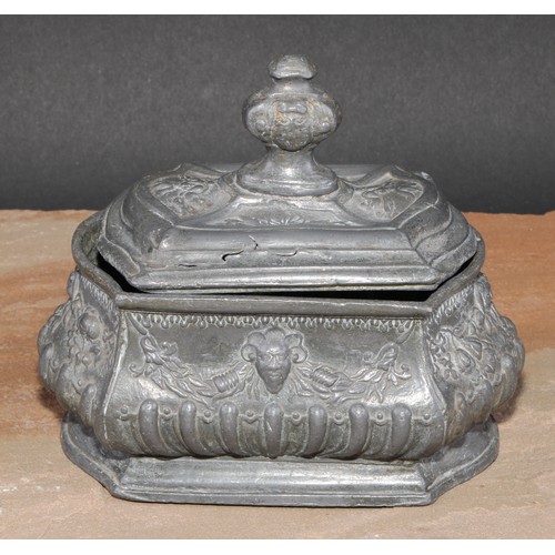 214 - A French lead half-fluted bombe shaped tobacco box, in relief with Baroque masks and swags, skirted ... 