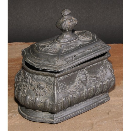 214 - A French lead half-fluted bombe shaped tobacco box, in relief with Baroque masks and swags, skirted ... 