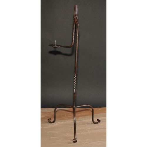 406 - A wrought iron nip rushlight holder, the hinged arm with pricket candlestick, twisted pillar, 56cm h... 