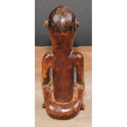 844 - Tribal Art - an African female figure, seated, cross-legged, 15cm high