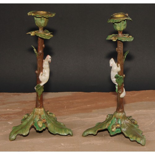 318 - A pair of Austrian cold painted bronze novelty candlesticks, each cast with a squirrel climbing amon... 