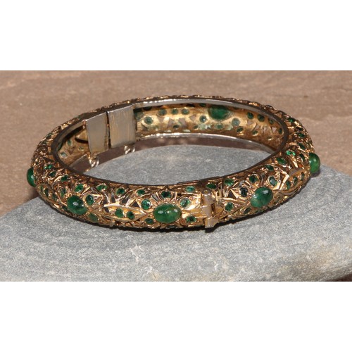 232 - A gilt metal and green stone hinged bangle, possibly Indian, 8cm