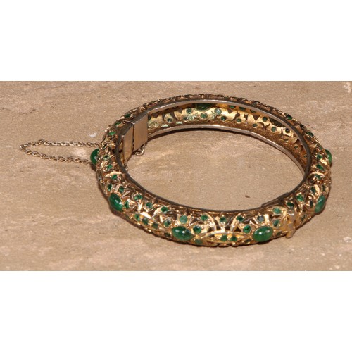 232 - A gilt metal and green stone hinged bangle, possibly Indian, 8cm