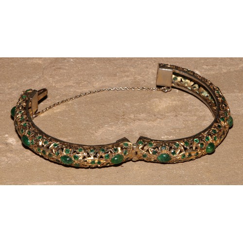 232 - A gilt metal and green stone hinged bangle, possibly Indian, 8cm