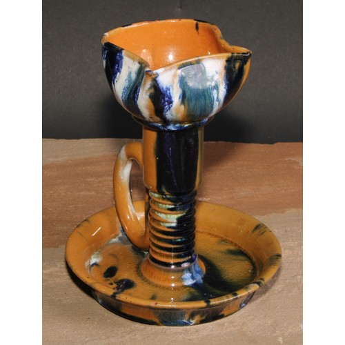 436 - An Art pottery chamber stick, in the manner of Christopher Dresser, glazed in mottled tones of blue ... 