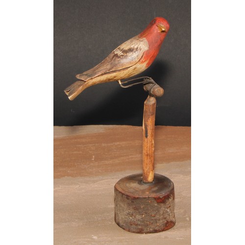 556 - Folk Art - a soft wood avian model, carved and painted as a bird on a perch, 21cm high