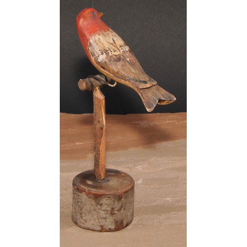 556 - Folk Art - a soft wood avian model, carved and painted as a bird on a perch, 21cm high