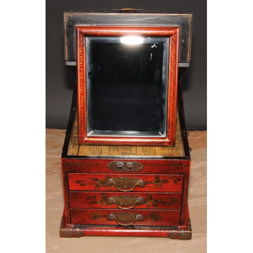 175 - A Chinese red lacquer table top vanity chest, hinged cover enclosing a folding mirror, above three d... 