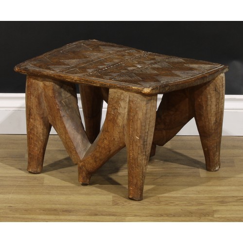 835 - Tribal Art - a Nupe stool, the rectangular top carved with geometric motifs, 30cm high, 48cm wide, C... 