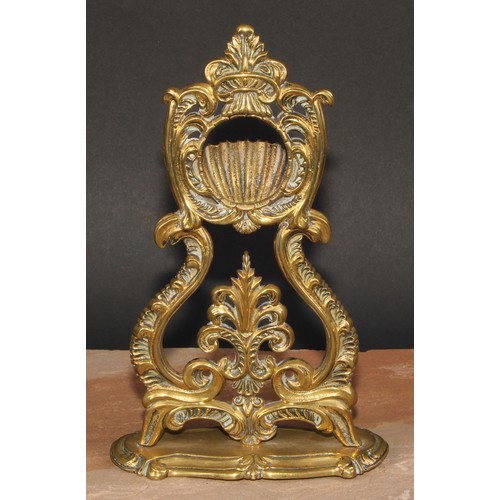 24 - A 19th century brass pocket watch stand, cast throughout with leafy scrolls, shaped oval base, 24.5c... 