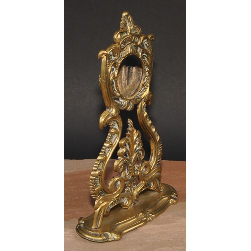 24 - A 19th century brass pocket watch stand, cast throughout with leafy scrolls, shaped oval base, 24.5c... 