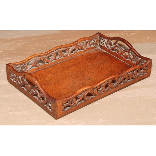 72 - A 19th century mahogany letter tray, the shaped gallery pierced and carved with scrolling flowering ... 