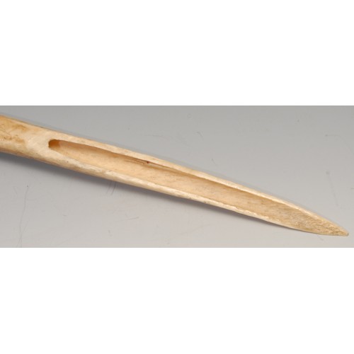 836 - Tribal Art - a Papua New Guinea Cassowary bird bone dagger, embellished with feathers and knotted se... 