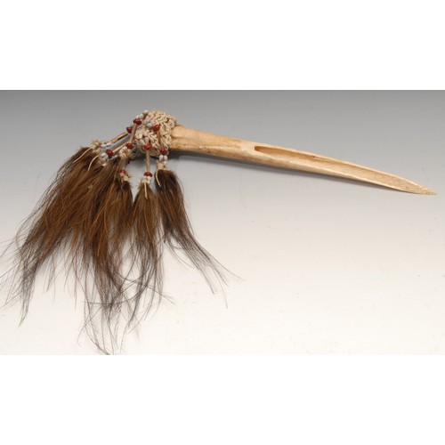 836 - Tribal Art - a Papua New Guinea Cassowary bird bone dagger, embellished with feathers and knotted se... 