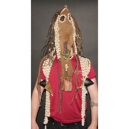 822 - A Dogon girl's helmet mask and vest, stocked with cowrie shells and 'plaited hair' applied with bell... 