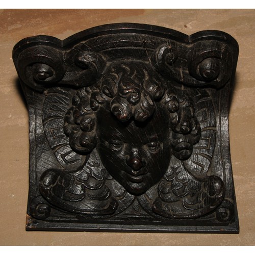 83 - A 19th century oak corbel wall bracket, boldly carved with a putto mask, 21.5cm wide