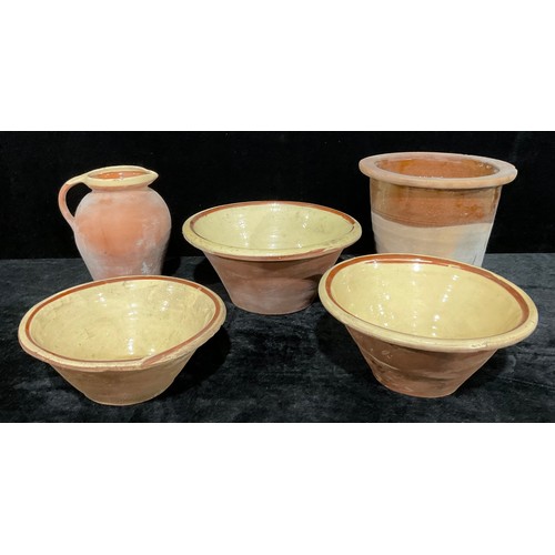 594 - A graduated set of three 19th century terracotta pancheon bowls, cream slip glazed interior, the lar... 