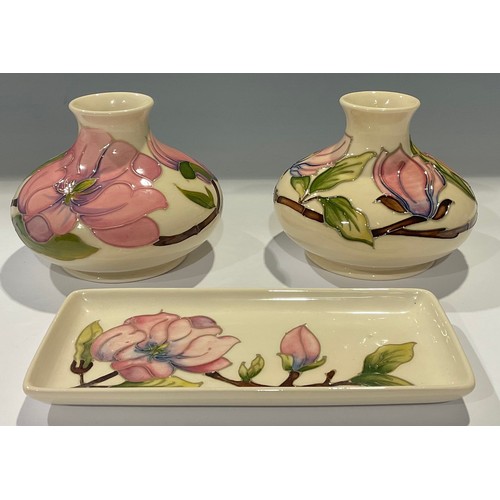 32 - A pair of Moorcroft Magnolia pattern compressed ovoid vases, 10cm, impressed and painted marks; a Mo... 