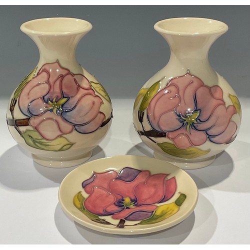 137 - A pair of Moorcroft Magnolia pattern ovoid bottle vases, 14cm, impressed and painted marks; a Moorcr... 